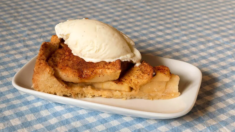 Apfelkuchen mit einer Kugel Vanilleeis als Serviervorschlag